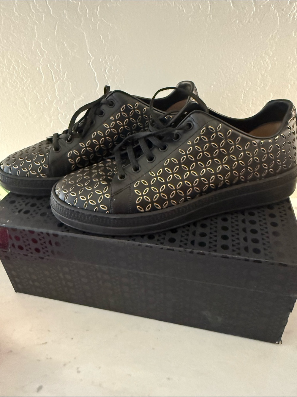 Alaia Black Leather Sneakers with Gold Cutout Pattern
